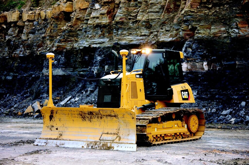 A GPS-equipped bulldozer on a construction site, showcasing advanced machine control technology for precise grading and efficient site preparation against a rocky terrain backdrop.